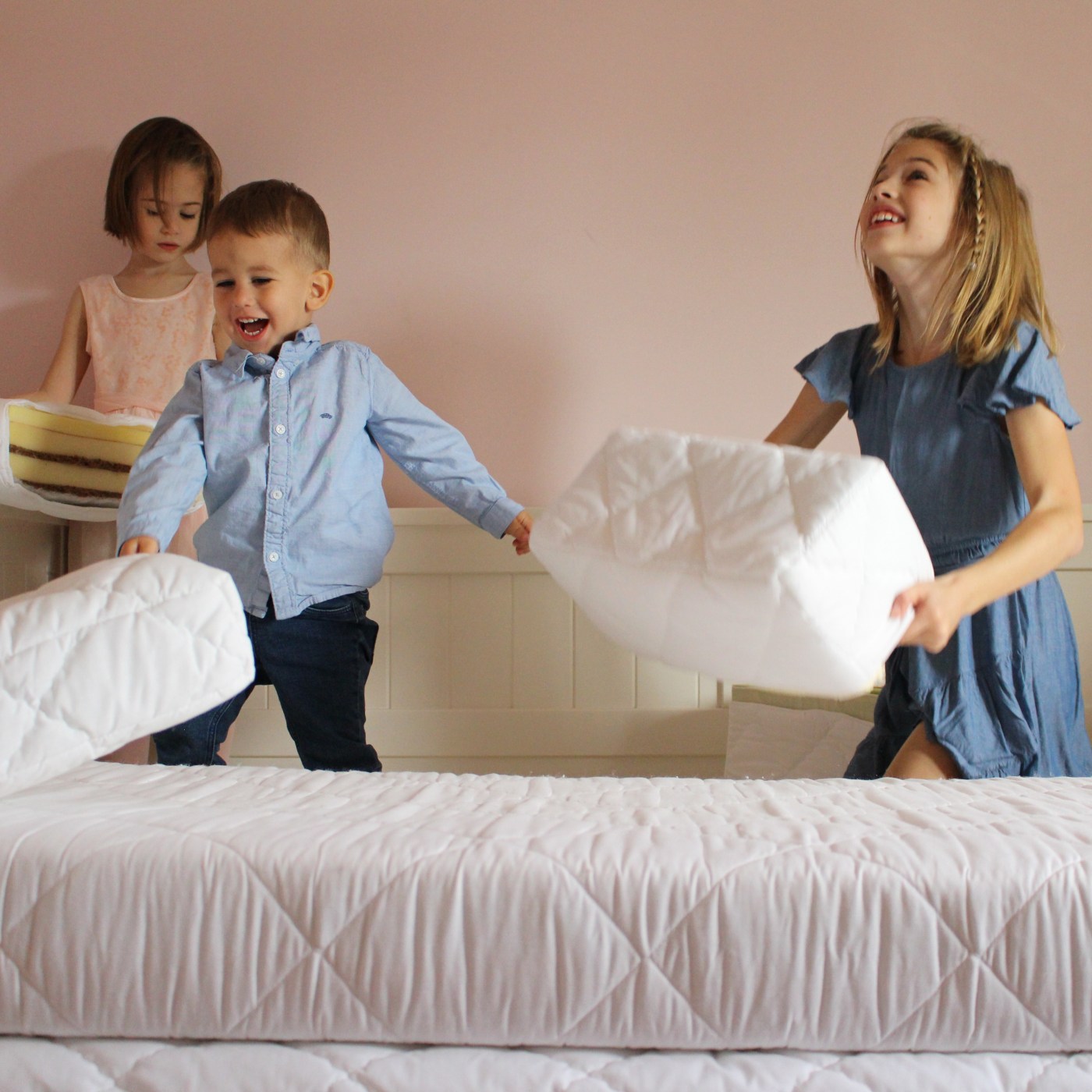 három kisgyerek matracmintákkal játszik, ugrálnak